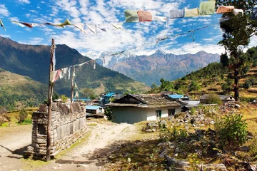 Fotobehang Prayer wall, prayer flags and village in Nepal © Daniel Prudek