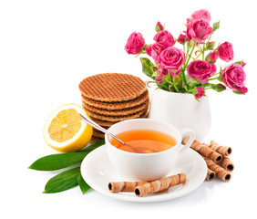 tea in cup with biscuits and lemon isolated on white background