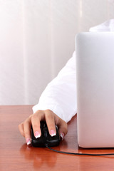 Fototapeta premium woman's hands pushing keys of pc mouse, close-up