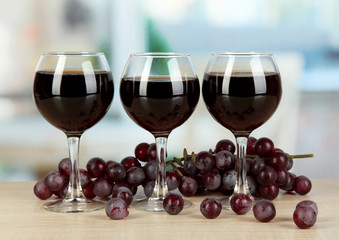 Red wine in glass on room background