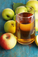 Useful apple juice with apples around on wooden table