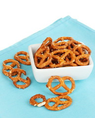 Tasty pretzels in white bowl isolated on white