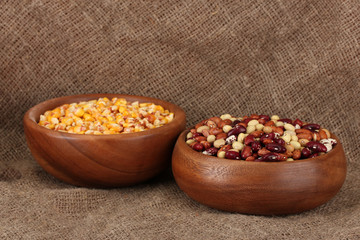Raw corn, and beans in wooden bowls