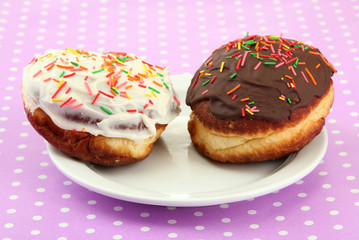 Tasty donuts on color plate on color background