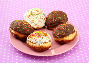 Tasty donuts on color plate on color background