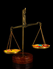Classic scales with color pills isolated on black