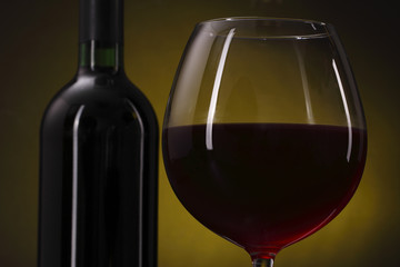 Red wine glass on the yellow background