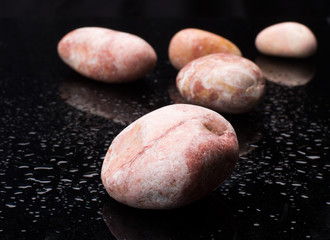 pebble on black glass with water drops