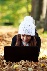 Beautiful young girl with laptop in autumn park. Young European - 48204372
