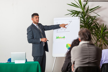 Naklejka premium Young Businessman Explaining Plans and Charts
