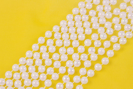 beads from white pearls on yellow fabric