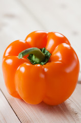 Orange bell pepper on wooden boards, studio shot