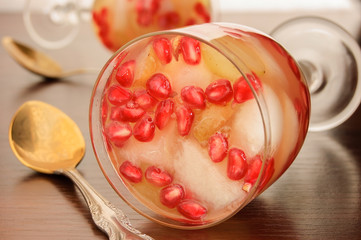 Jelly with fruits in glass on wooden table