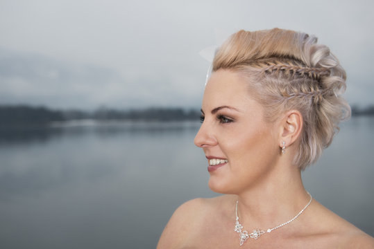 Eine junge blonde Braut mit geflochtener Frisur