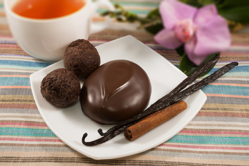 marshmallow on a saucer with a cup of  black tea and a flower