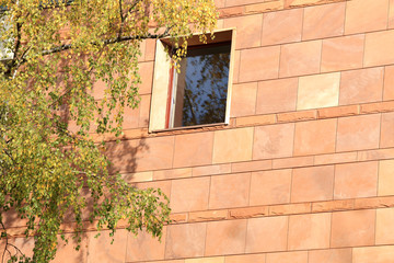 Ściana budynku z oknem z jasno brązowych płytek, Filharmonia Opolska.