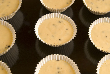Raw dough into muffins in the forms .