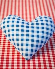 Obraz premium Blue heart on gingham tablecloth