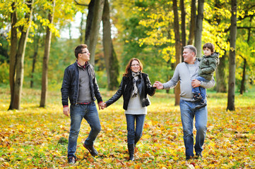 Obraz premium Happy family walking together in a park