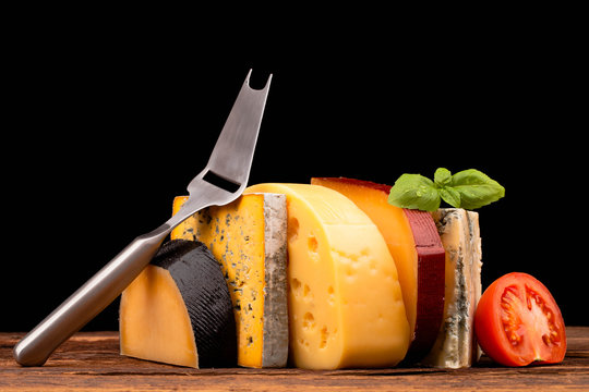 Various types of cheese and knife isolated on black
