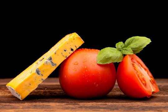 Various types of cheese and tomatoes isolated on black