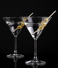 Martini glasses and olives isolated on black