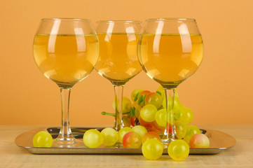White wine in glass on salver on beige background