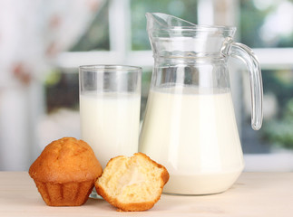 Pitcher and glass of milk with muffins