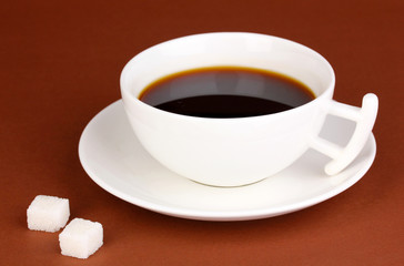 A cup of strong coffee on brown background