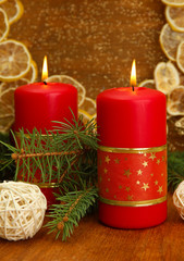 Two candles and christmas decorations, on golden background