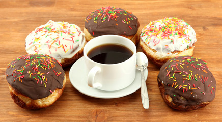 Tasty donuts on color plate on wooden background
