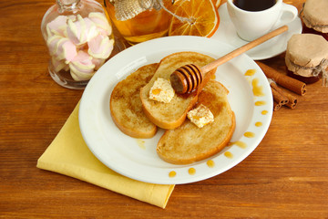White bread toast with honey and cup of coffee on wooden table