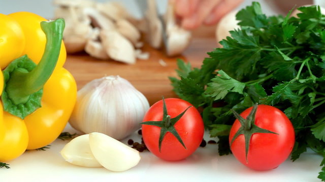 Female hands chopping mushrooms. Focus on vegetables