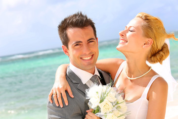 Cheerful married couple standing on the beach