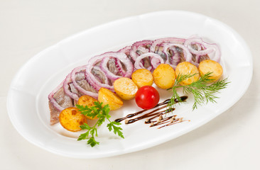 Boiled potato with a herring and an onions