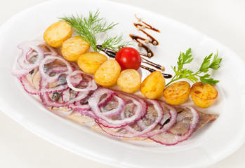 Boiled potato with a herring and an onions