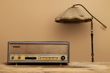 old radio on wooden table with floor lamp