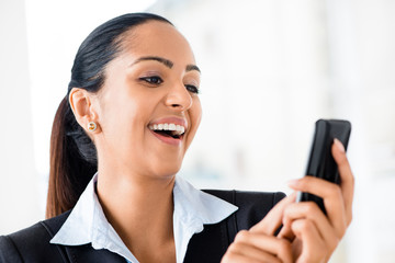 Closeup portrait of beautiful Indian businesswoman sending text