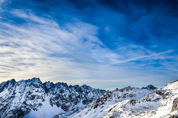 Fototapeta na wymiar Zimowe Tatry Wysokie góry krajobraz z niebieskim pochmurne niebo