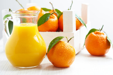 Orange juice in pitcher and tangerines