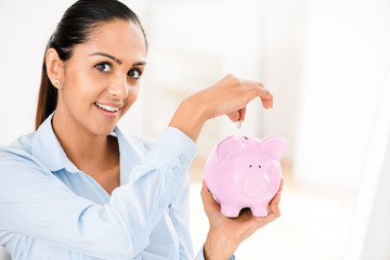 Indian business woman saving money piggy bank