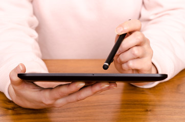 Hände einer Frau mit Stift und Tablet Computer