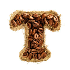 Alphabet from coffee beans on fabric texture isolated on white