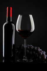 bottle with red wine and glass and grapes