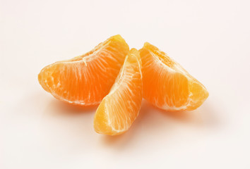 Three slices of tangerine on white background