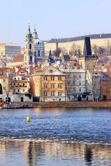 Naklejka premium Snowy Prague St. Nicholas' Cathedral in the sunny Day