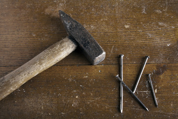 Hammer mit Nägel auf Holzuntergrund