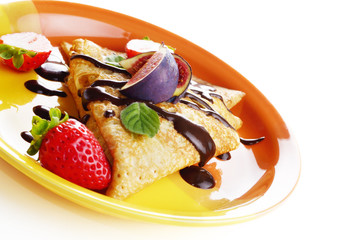 Strawberry crepes with chocolate syrup and figs over white