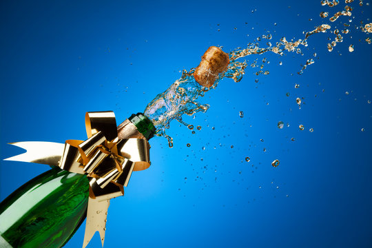 Cork popping from Champagne bottle with splashes