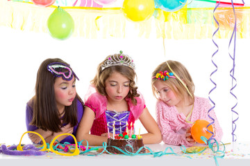 children happy girls blowing birthday party cake